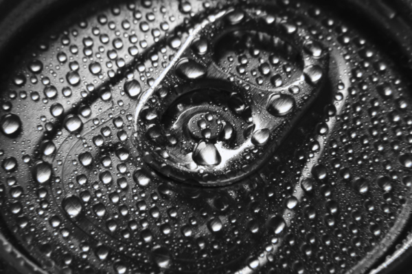 Close-Up Of Aluminium Beverage Can Drink With Water Drops. Closed Beer Can With Drops Of Water Condensate.